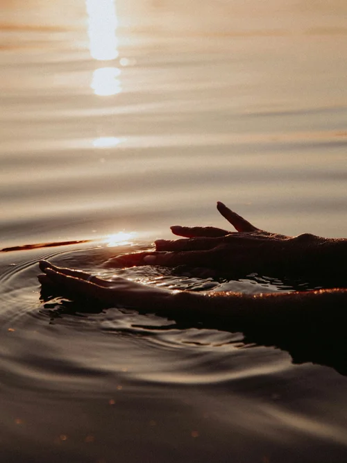 Green Lake Hotel Weiher: 4-star superior hotel in Val Pusteria Hands gently touching water at sunset