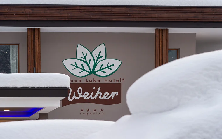 Absolutely stunning impressions Snow-covered Green Lake Hotel Weiher building with logo and stars