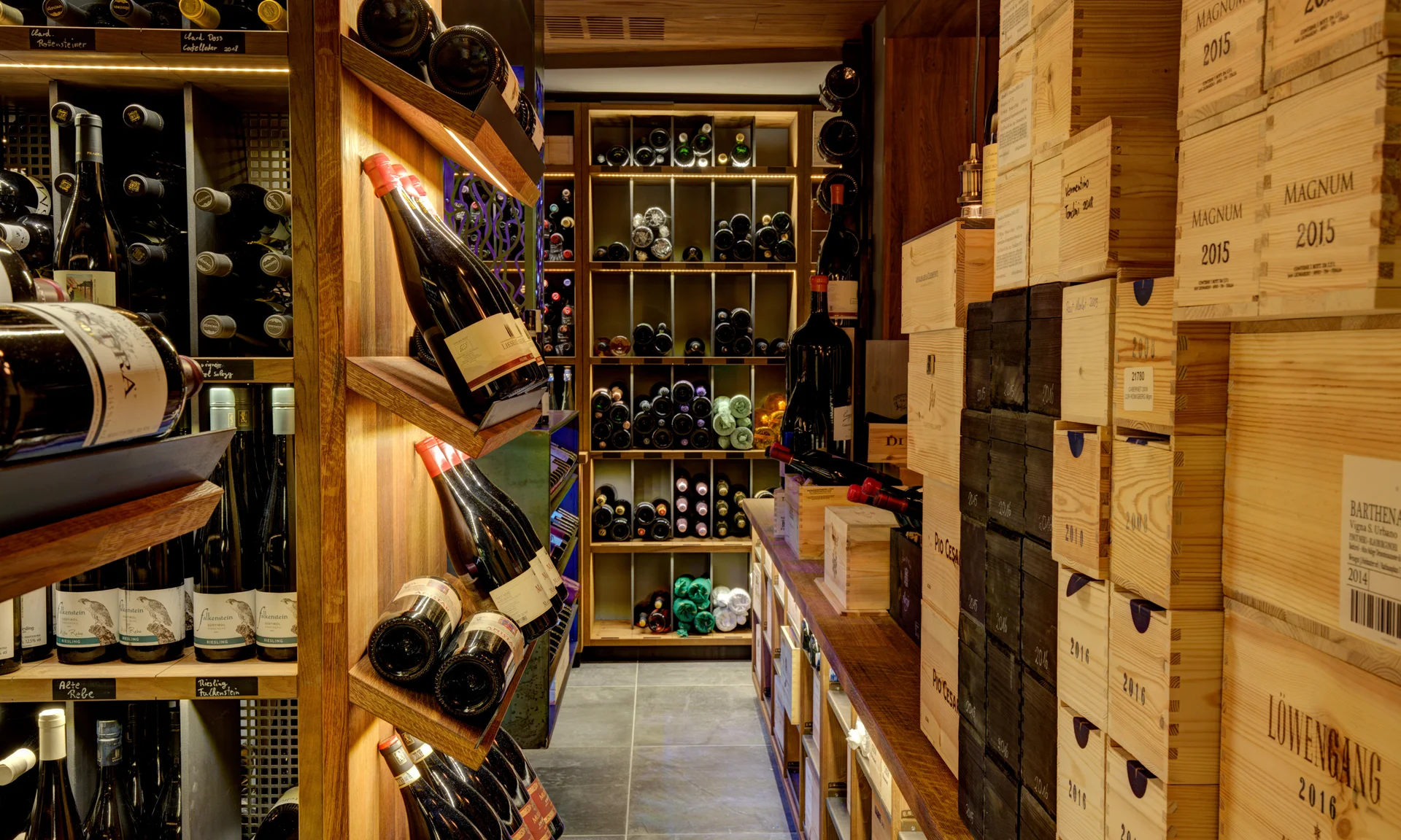 Cantina dei vini e bar al Green Lake Hotel Weiher Cantina con scaffali pieni di bottiglie di vino e casse di legno