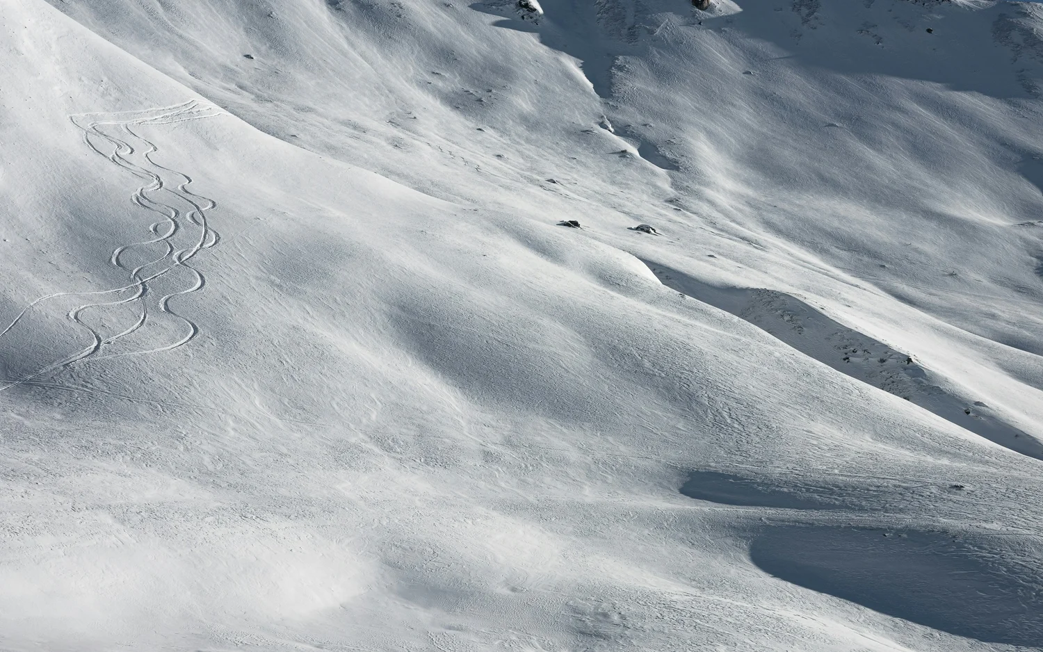 Schneebedeckter Hang mit Spuren von Skifahrern