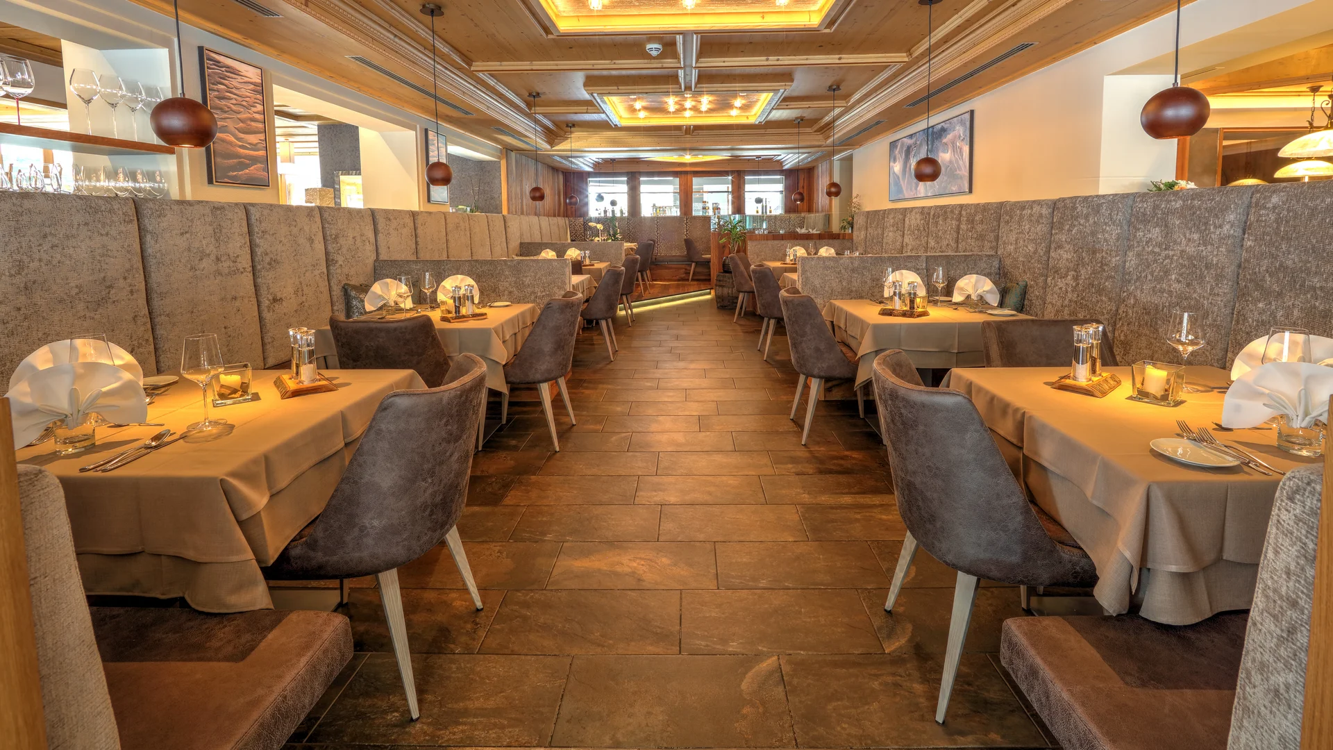 Entschleunigen und genießen in diesem Hotel nahe Bruneck Elegantes Restaurant mit gedeckten Tischen und gemütlichen Stühlen