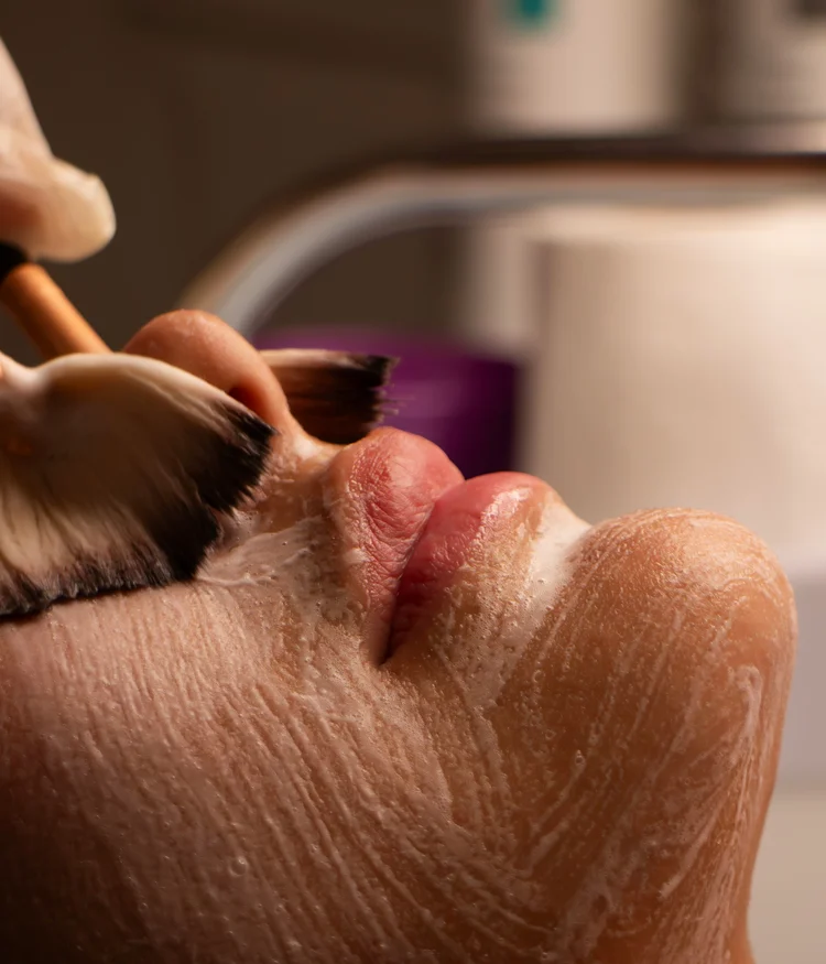 Close-up of facial treatment with brush applying foam on skin