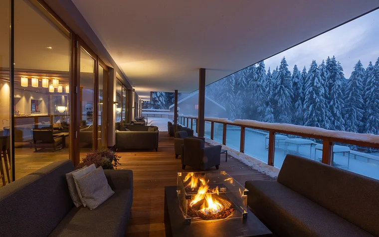 Absolutely stunning impressions Cozy terrace with fireplace and view of snow-covered pine trees