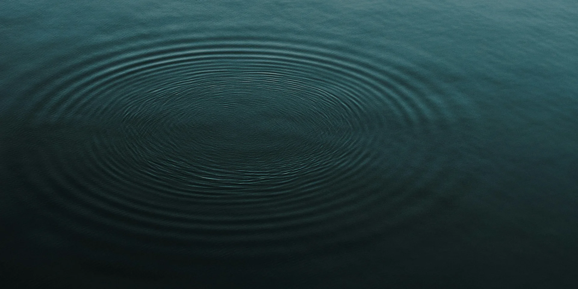 Sanfte Wellenringe auf ruhiger Wasseroberfläche bei Dämmerung