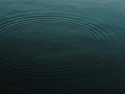 Sanfte Wellenringe auf ruhiger Wasseroberfläche bei Dämmerung