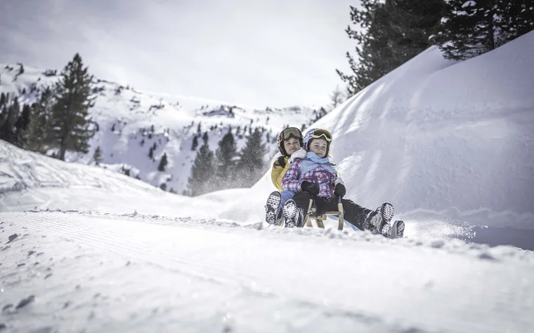 Da cartolina, queste immagini Due persone scendono su una slitta lungo una pista innevata