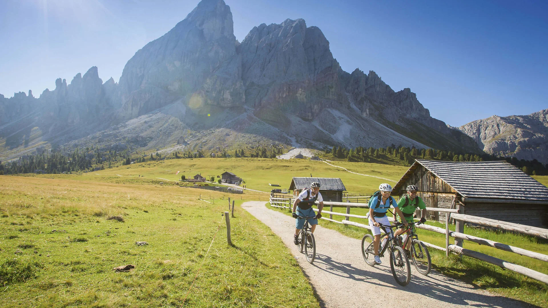 Drei lohnende Touren mit E-Bike im Pustertal Drei Radfahrer fahren auf einem Weg in den Bergen bei Sonnenschein