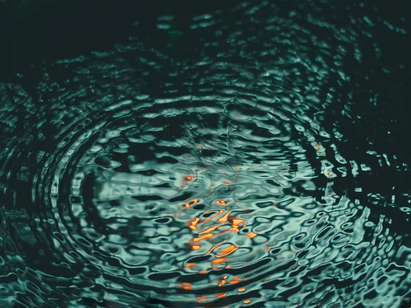Green Lake Hotel Weiher: 4-star superior hotel in Val Pusteria Water surface with concentric ripples and orange reflections
