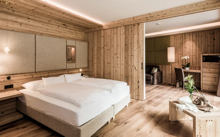 Modernes Hotelzimmer mit Holzverkleidung und großem Bett