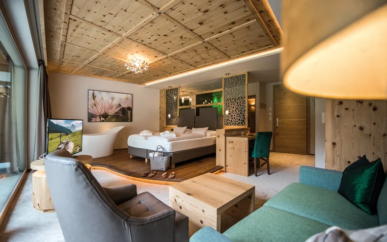 Modernes Hotelzimmer mit Holzmöbeln, Doppelbett und großer Fensterfront
